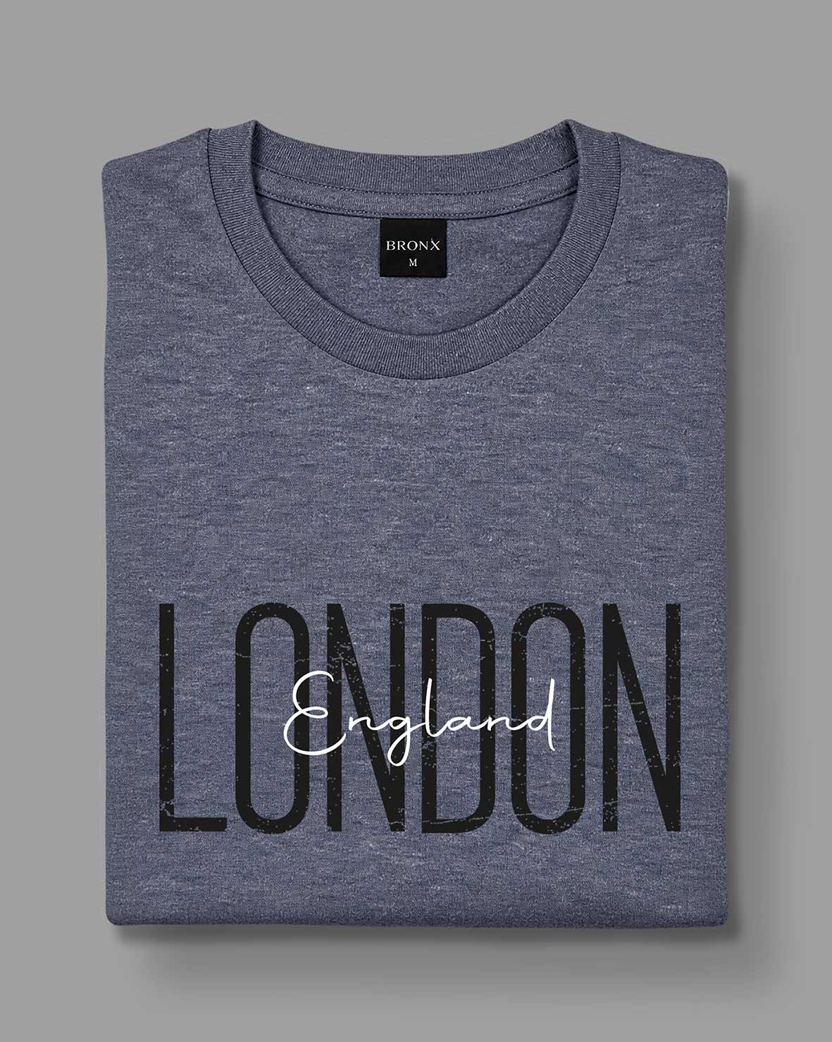 Polera London England gris azulado de BRONX doblada, con estampado visible.